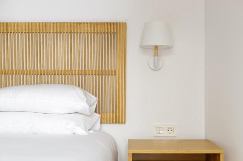 a bedroom with a bed and a table with a lamp at Caleta Homes - Apartamentos Pompidou in Málaga