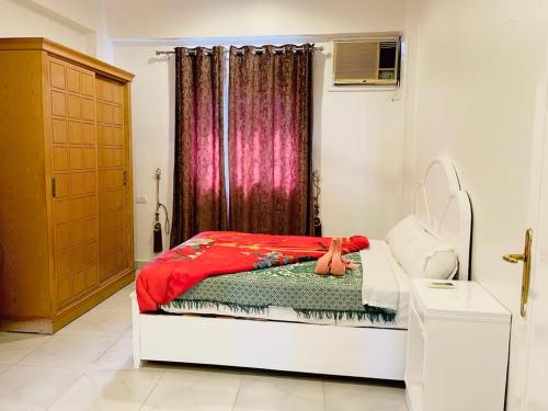 a bedroom with a bed with a red blanket at El Mesala Hotel in Luxor