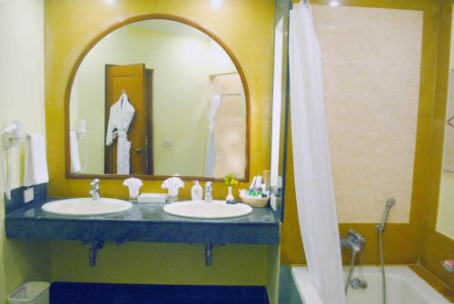 a bathroom with two sinks and a large mirror at The Hans Coco Palms in Puri