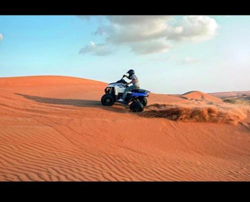 a person riding a quad bike in the desert at SandGlass Camp in Bidiyah