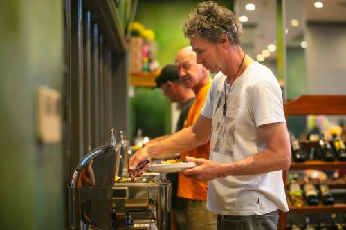 a man is holding a plate of food at Hanoi Nostalgia Hotel & Spa in Hanoi