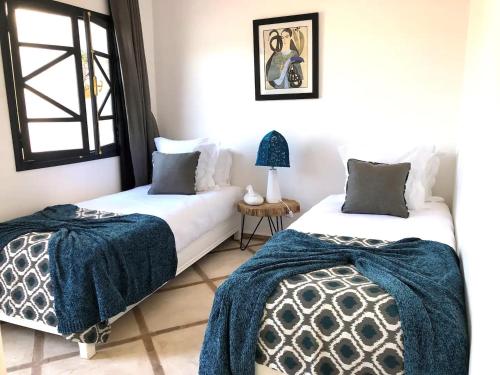 duas camas sentadas uma ao lado da outra num quarto em RIAD HAWWA JANNA - Privatif em Marrakech