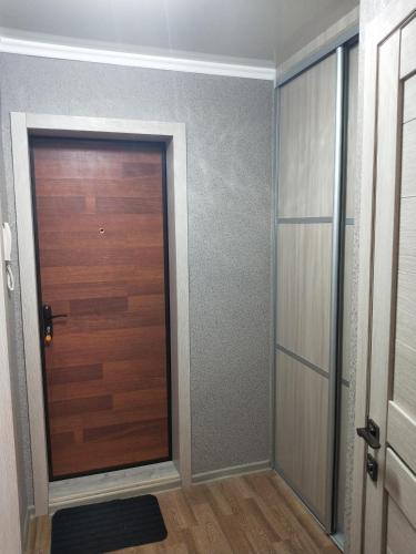 einen Flur mit einer Holztür und einem Zimmer in der Unterkunft Абая in Petropawlowsk