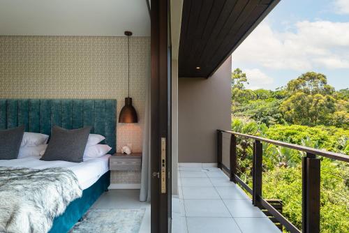 a bedroom with a bed and a balcony with a view at Luxury 3 Bed Villa- Zimbali Coastal Resort Retreat in Ballito