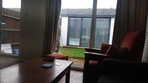 a living room with a couch and a table and a window at Fully Equipped Modern 3 bedroom House in Bishops Stortford