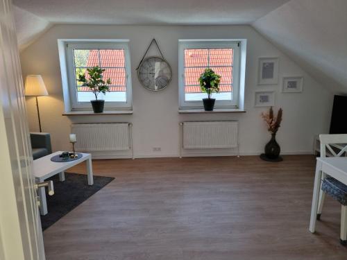 uma sala de estar com duas janelas com vasos de plantas em Ferienwohnung am Springerhof em Schönefeld