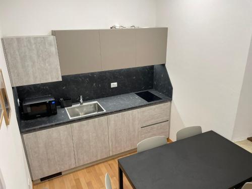a small kitchen with a sink and a table at House of Bruno Apartments - NO Reception in Trento