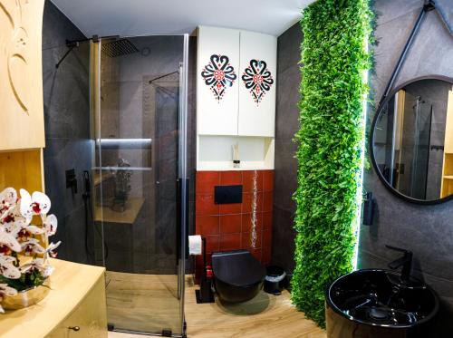 ein Bad mit einer Dusche und einer grünen Wand in der Unterkunft WILLA GRG in Zakopane