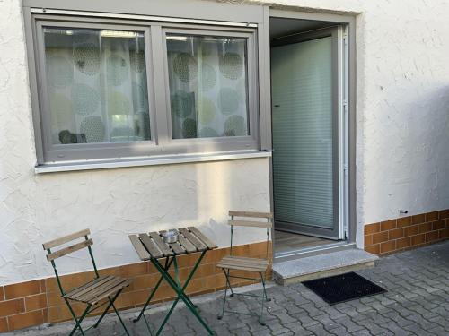 2 chaises et une table devant une fenêtre dans l'établissement Appartement für Monteure 18qm, à Weiterstadt