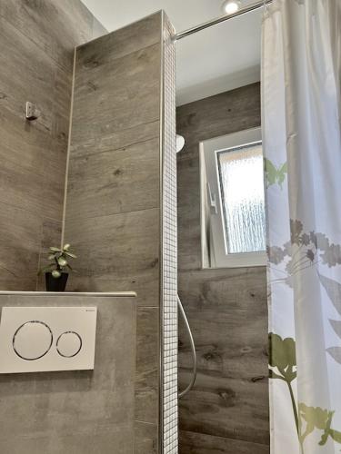 La salle de bains est pourvue d'une douche avec rideau de douche. dans l'établissement Appartement für Monteure 18qm, à Weiterstadt