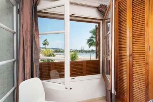 a bathroom with a window with a tub and a view of the ocean at Apartment Rovelló - Port d'Alcúdia in Port d'Alcudia