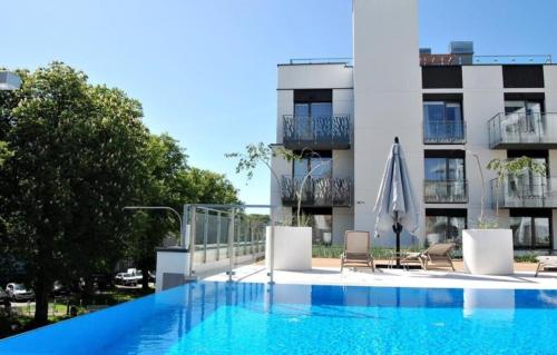 a swimming pool in front of a building at Apartamenty BalticON Nadmorskie Tarasy in Kołobrzeg