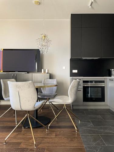 una sala da pranzo con sedie bianche e tavolo di visiting apartments - Wyspa Słodowa a Breslavia