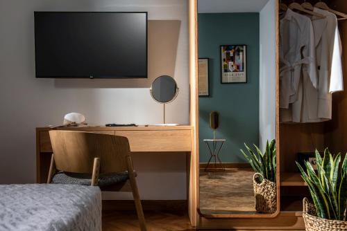 Télévision ou salle de divertissement dans l'établissement Kipos Boutique Suites