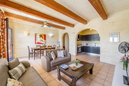 a living room with a couch and a table at The Blue House Holiday Home in Xagħra