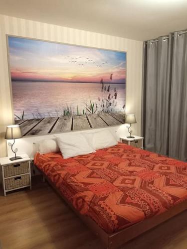 une chambre avec un lit avec un tableau sur le mur dans l'établissement Résidence Gascogne, Appartement Rose Boréal, à Eaux-Bonnes