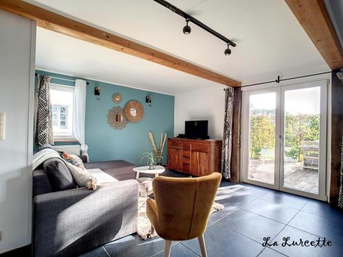 uma sala de estar com um sofá e uma cadeira em Holiday home le Lurçon et la Lurcette em Libin