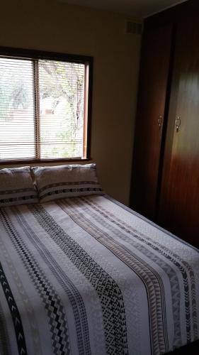 a bed in a room with a window at Grootgeluk in Naboomspruit