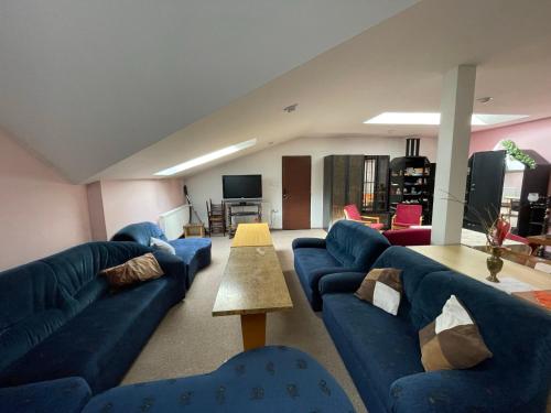 a living room with blue couches and a table at Apartments Ubytování U Zemanů in Chrášťany