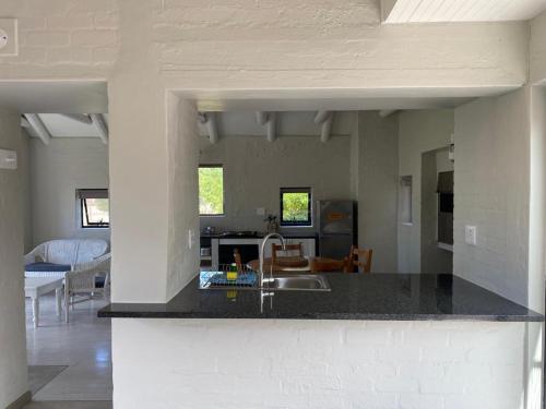 a kitchen with a sink and a living room at Blue Bay Lodge in Saldanha