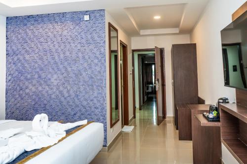 a hotel room with a blue tile wall at Marksman Resort in Bangalore