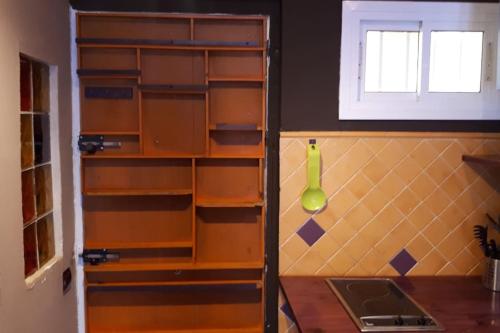 a kitchen with wooden shelves and a green vase on the wall at Sol y playa in Benalmádena