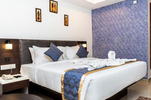 a bedroom with a large bed with towels on it at Marksman Resort in Bangalore