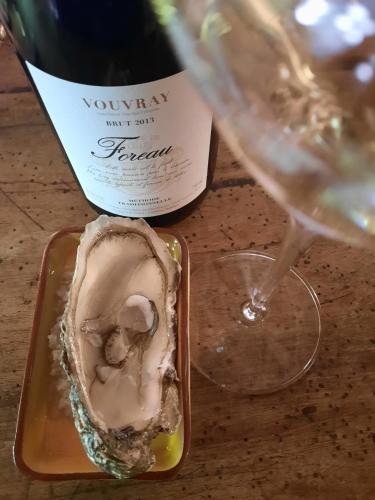 a bottle of wine and a oyster and a glass at DOMAINE DE LABROUSSE, Maison d'hôtes en Périgord in Agonac