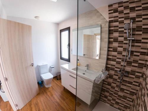 a bathroom with a shower and a sink and a toilet at Villa Romans in Caleta De Fuste