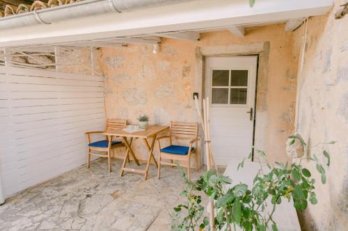 een patio met een tafel en 2 stoelen bij Romantic Stone House Double room in Kornić