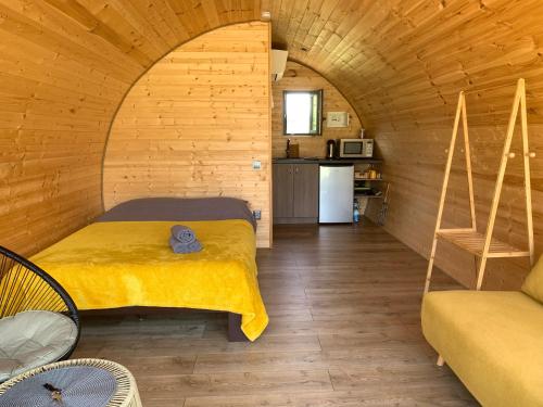 1 dormitorio con 1 cama en una habitación de madera en Kedras Glamping - Pod tipo nameliai en Prapuntai