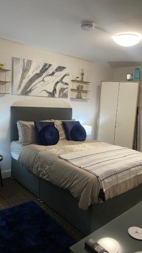 Un dormitorio con una cama con almohadas azules. en Bv Homely Studio Fourteen At Deighton Huddersfield, en Huddersfield