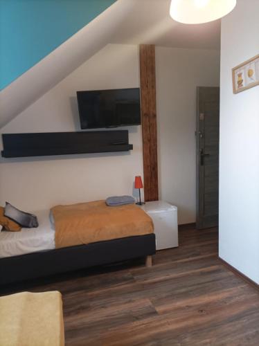 a bedroom with a bed and a tv on the wall at Ostoja Karkonoska in Podgórzyn