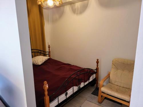 a small bedroom with a bed and a chair at Apartment near the Harbour in Turku