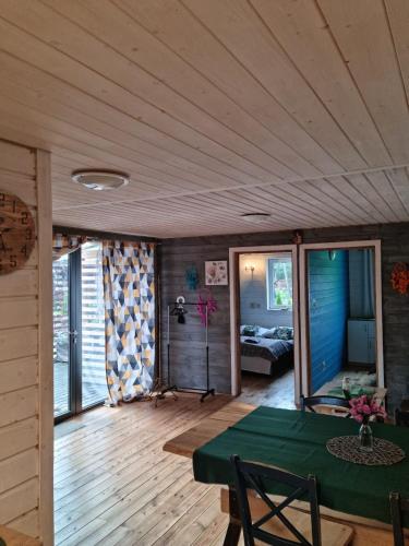 a living room with a green table and a bedroom at Ostoja Karkonoska in Podgórzyn