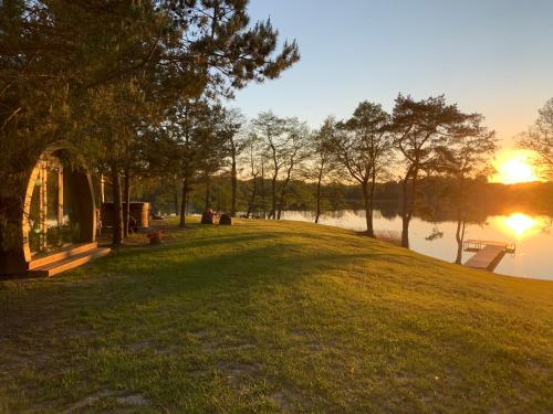 a view of a lake with the sun setting at Kedras Glamping - Pod tipo nameliai in Prapuntai