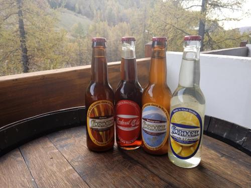 拉富的住宿－Résidences de Mélisa La Foux d'Allos，阳台上的桌子上放着四个啤酒瓶