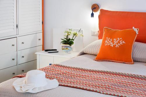 a bedroom with an orange pillow on a bed at Sofì Sorrento Suites in Sorrento