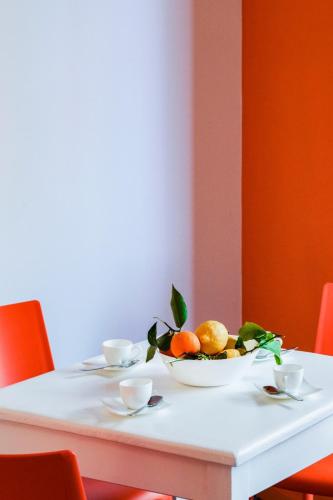 a white table with a bowl of fruit on it at Sofì Sorrento Suites in Sorrento