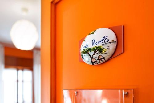 a sign on an orange wall with a tree on it at Sofì Sorrento Suites in Sorrento