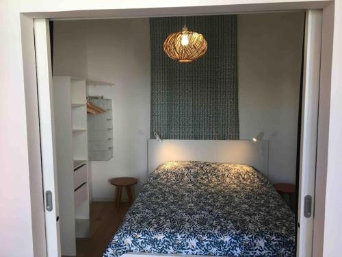 a bedroom with a bed and a chandelier at HYPER CENTRE CLIM T2 NEUF - OLD PORT 1.5KM in Marseille