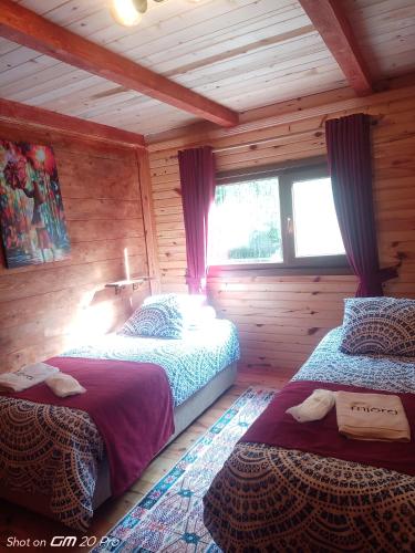 1 dormitorio con 2 camas en una cabaña de madera en MJORA Bungalov Ayder, en Güroluk
