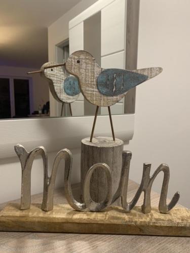 a wooden bird sitting on top of a wooden sign at Schillig, Nordsee - Friesland - Wohnung - neu in Wangerland