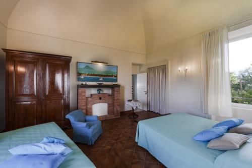 1 dormitorio con 2 camas y chimenea en Villa Preziosa al Pizzo 3 km da Sorrento en Sant'Agnello
