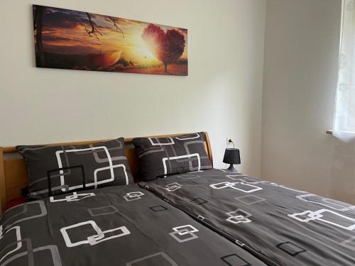 1 dormitorio con 1 cama con una foto en la pared en Ferienwohnung 11 Haus Feldbergblick, en Lenzkirch