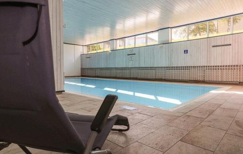 a swimming pool with a chair in front of it at Appartement Wettersteinblick mit Sauna und Pool in Seefeld in Tirol