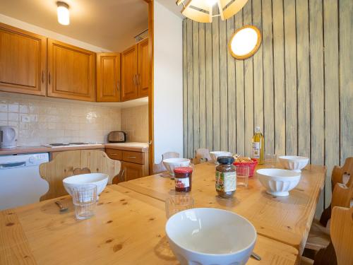 a kitchen with a wooden table with bowls on it at Apartment Origanes 226 by Interhome in Les Menuires
