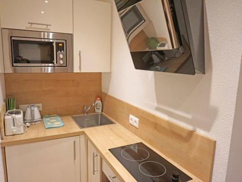 a small kitchen with a sink and a microwave at Apartment Alpengruss by Interhome in Oberlehn