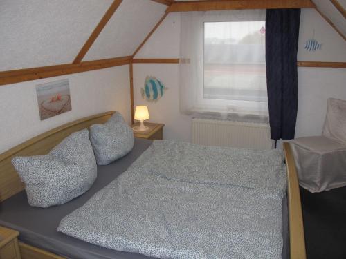 a small bedroom with a bed and a window at Holiday Home Ostwind by Interhome in Ummanz