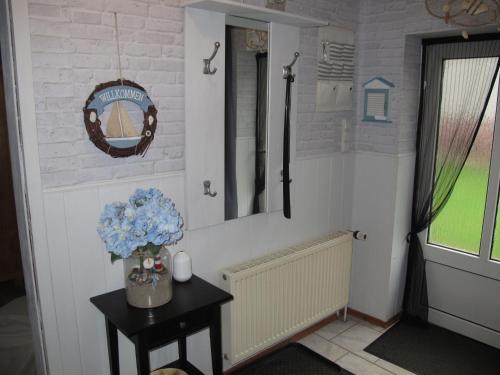 a bathroom with a vase of blue flowers on a table at Holiday Home Ostwind by Interhome in Ummanz